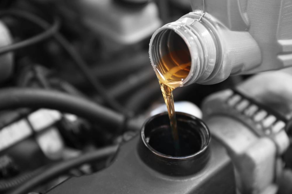 Oil Changes Pouring oil to car engine, close up